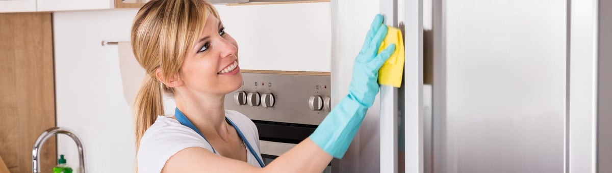 naine puhastab köögis külmkappi