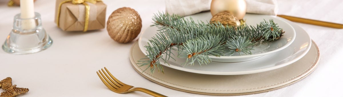 moodne jõululaud valgete laudlinade ja kuldsete söögiriistadega