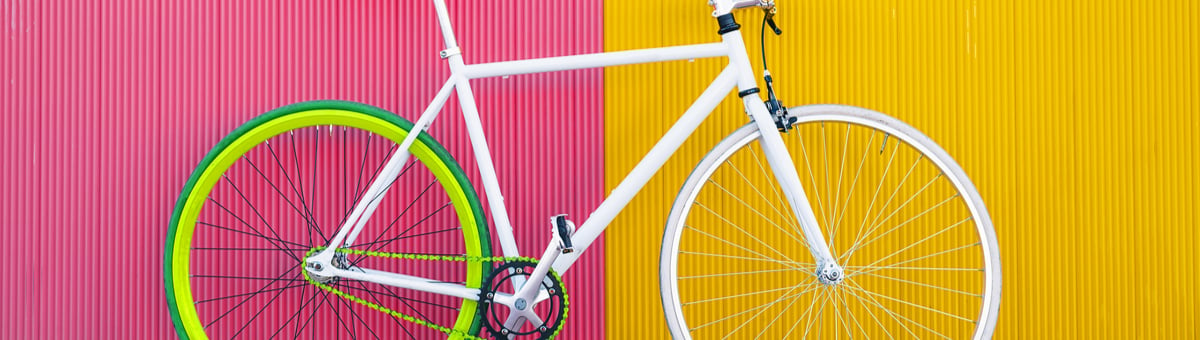valge jalgratas kollase ja roosaga taustal