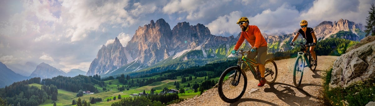 мужчина и женщина катаются на велосипедах в горах
