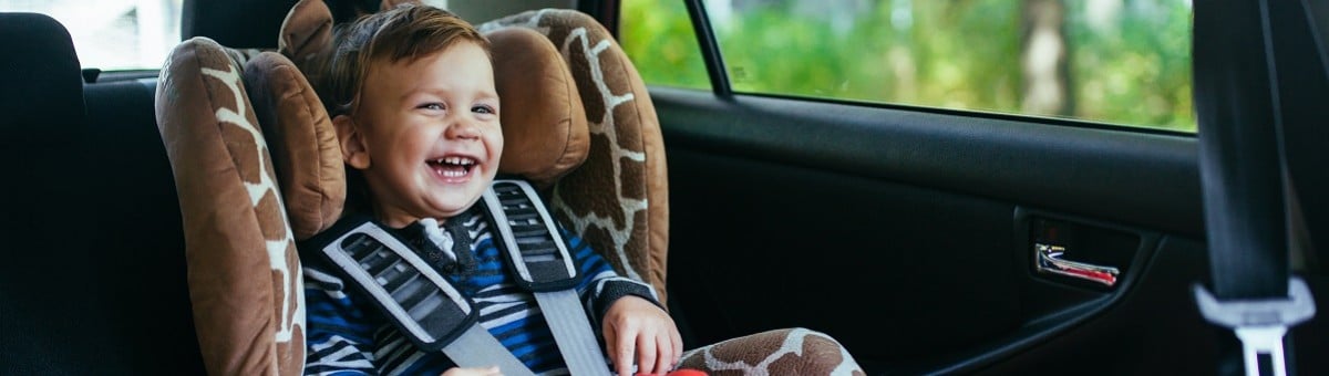naeratav laps istub autos turvatoolis
