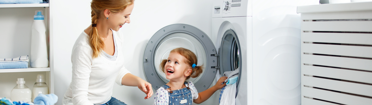 naine ja laps panevad eestlaetavasse pesumasinasse pesu sisse